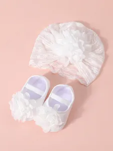 Detailed view of baby lace flower turban hat and matching soft sole princess shoes set