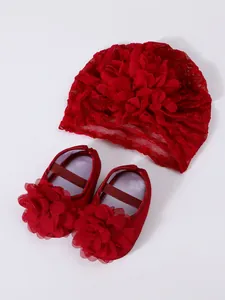 Detailed top view of red lace baby turban hat and matching flower princess shoes set