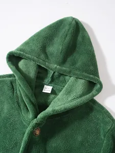 Close-up detail of a soft green coral fleece hooded jacket featuring label and button