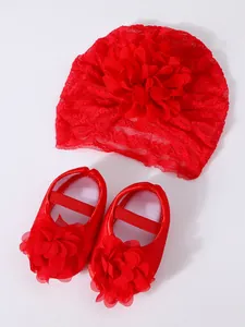 Close-up detail of red lace infant turban and matching 3D floral princess shoes