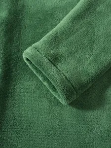 Detailed macro shot of soft green coral fleece sleeve cuff on men's warm hooded jacket