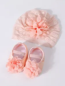 Close-up of pink baby lace turban hat and matching flower shoes set for newborn girls