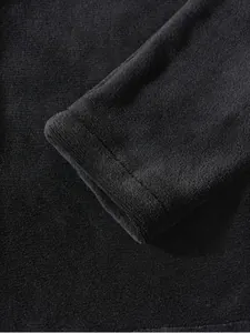 Close-up showing the soft texture of a black coral velvet fleece jacket sleeve cuff detail.