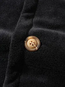 Detailed macro view of a brown marbled button on high-quality black coral fleece fabric