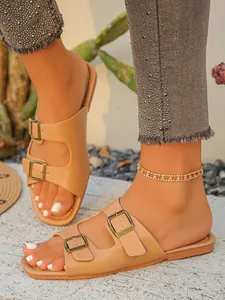 Schicke flache Damen-Sandalen in Beige mit doppelter Schnalle in einer Outdoor-Umgebung