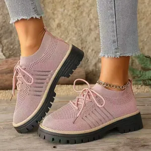 Dettaglio di scarpe da ginnastica rosa traspiranti con suola platform su legno