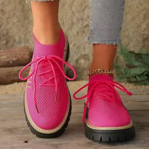Dettaglio di sneaker traspiranti in maglia rosa acceso con spesse suole a piattaforma
