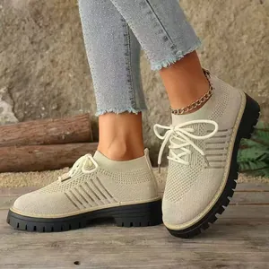 Primo piano di scarpe da donna in maglia traspirante con suole nere spesse e lacci