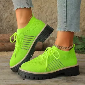 Vista ravvicinata di sneakers platform traspiranti in maglia verde neon su un ponte in legno