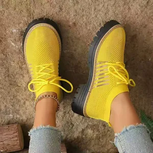 Dettaglio dall'alto di sneakers gialle traspiranti in fly-knit con suola flatform