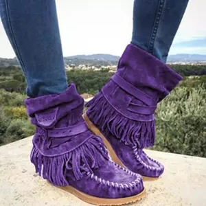 Gros plan de bottines en daim violet avec des franges et des boucles élégantes stylées.