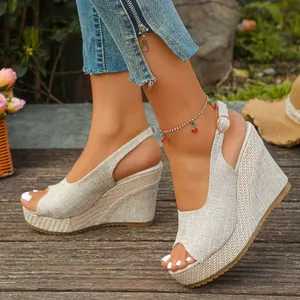 Detailed view of beige peep-toe wedge sandals with linen fabric texture and high platform