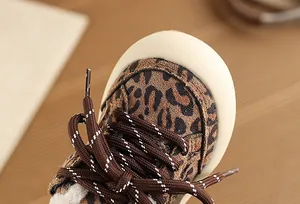 Macro view of leopard print kids shoe with brown laces and fuzzy lining