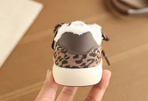 Close-up detail of leopard print children sneaker heel with cozy white faux fur lining