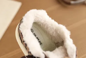 Detailed macro view of the thick white plush fleece lining inside children's winter shoes