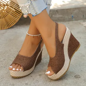 Detailed view of women brown linen peep-toe wedge sandals with woven platform base