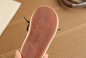 Close-up of children's sneaker sole featuring anti-slip zigzag tread and star detail.