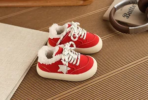 Close-up of red fleece-lined children's sneakers with star patch and thick sole.