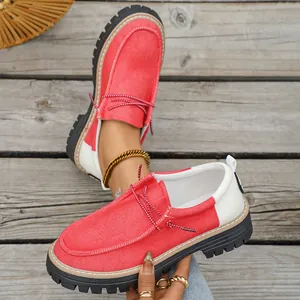 Detailweergave van retro rood-witte canvas loafers met dikke zwarte profielzolen.