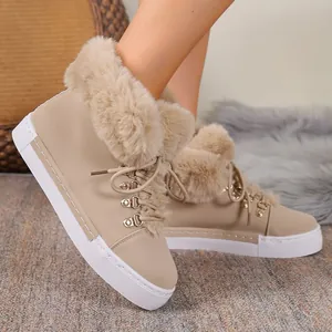 Close-up of women's tan leather snow boots featuring plush faux fur collar and white sole