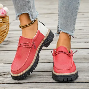 Detailopname van rood-witte patchwork canvas schoenen met dikke zolen en decoratieve veters