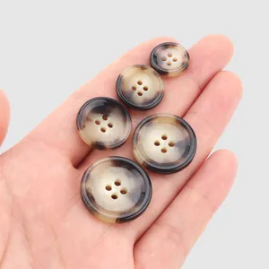 Set of five high-end tortoiseshell urea buttons displayed on a hand for scale.