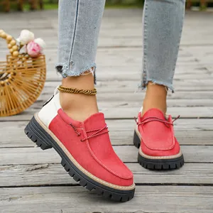 Gedetailleerd overzicht van rood-witte canvas instappers met plateauzool op een houten dek