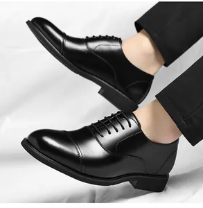 Detailed view of men's black cap-toe leather business dress shoes worn with trousers