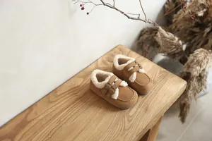 Gros plan de mocassins en daim marron pour enfants avec doublure en fourrure blanche