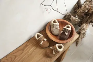 Détail artistique de chaussures pour tout-petits fourrées dans un bol en bois rustique chic