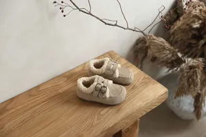 Mocassins en daim pour enfants avec doublure polaire sur un banc en bois rustique chic