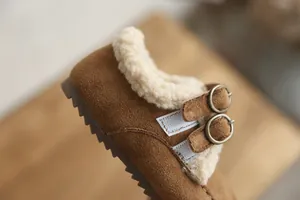 Gros plan de chaussures en daim pour enfants avec doublure en polaire chaude et boucles