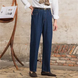 Classic men's straight-leg denim jeans in dark blue shown on model in a lifestyle set