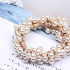 Close-up detail of a sweet pearl beaded hair tie with elegant rose gold metallic wrapping.