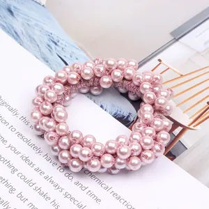 Detailed close-up of elegant pink faux pearl beads on a sweet elastic hair scrunchie