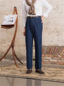 Classic men's dark blue straight-leg jeans paired with a white shirt and loafers