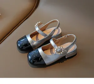 Primo piano di sandali per bambini argento e nero con fibbia in perle