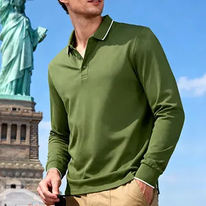 Lifestyle shot of men's olive green long-sleeved jacquard polo shirt outdoors with Statue of Liberty
