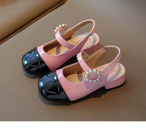 Vista dettagliata dei sandali in vernice rosa e nera per bambine con perle decorative