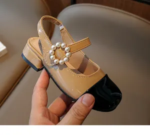 Primo piano del sandalo Mary Jane in vernice per bambina con fibbia di perle e punta