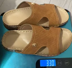Primo piano di sandali marroni con zeppa su una bilancia digitale per il peso