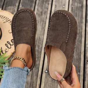 Detail view of brown suede Birkenstock-style mules with decorative toe stitching