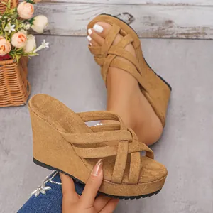 Gros plan de sandales compensées à plateforme en similicuir suédé beige avec brides croisées