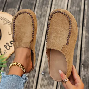 Detailed view of vintage brown suede clogs featuring contrast hand-stitched details
