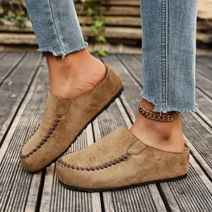 Detail view of khaki platform suede clogs with decorative stitching and thick sole