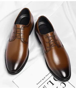 Detail of brown men's business dress shoes with gradient toe and lace-up design.