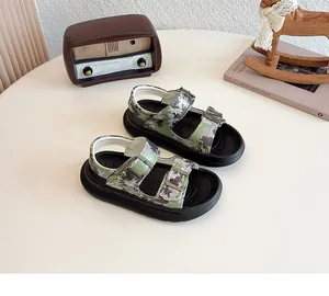 Kids camouflage print sandals with adjustable buckle straps and thick black soles.
