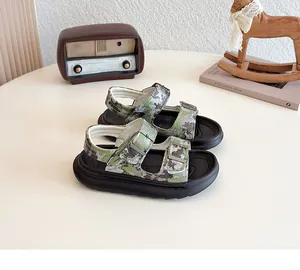 Macro view of stylish camouflage kids sandals with double buckle straps on a beige table
