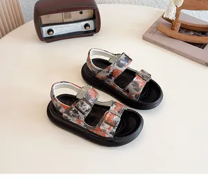 Detail view of children's camouflage sandals with adjustable buckle straps on a white table.