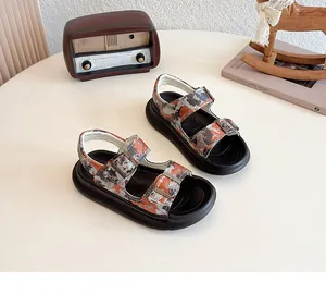 Close-up of stylish children's camouflage sandals with thick black soles and buckle straps